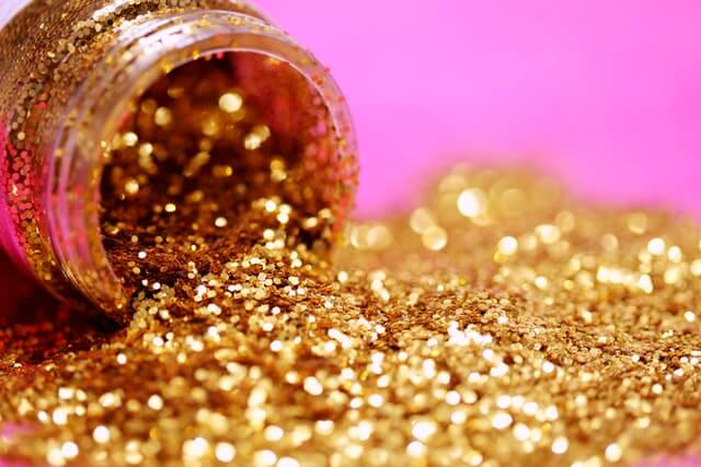 An open bottle of gold glitter